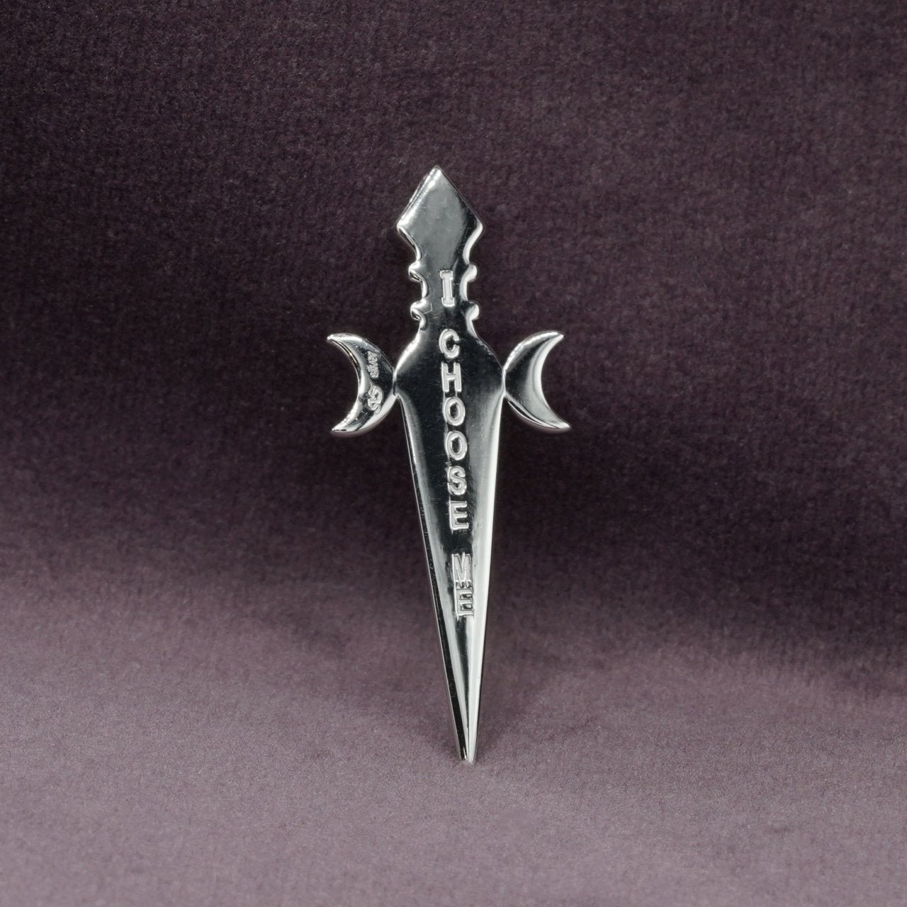 Silver sword-shaped pendant with 'I CHOOSE ME' text on a dark background