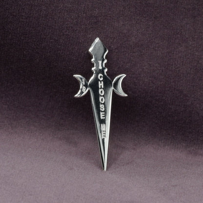 Silver sword-shaped pendant with 'I CHOOSE ME' text on a dark background