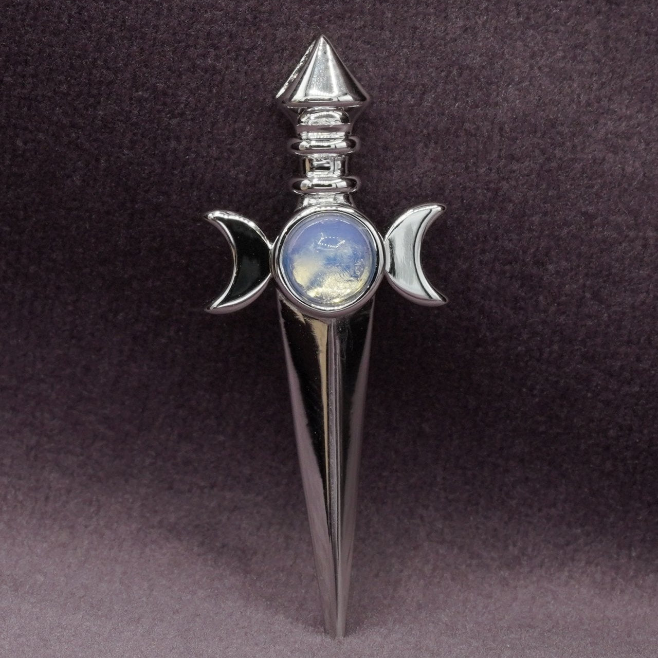 Decorative sword with a moonstone in the center on a dark background