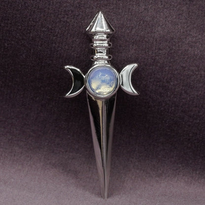 Decorative sword with a moonstone in the center on a dark background